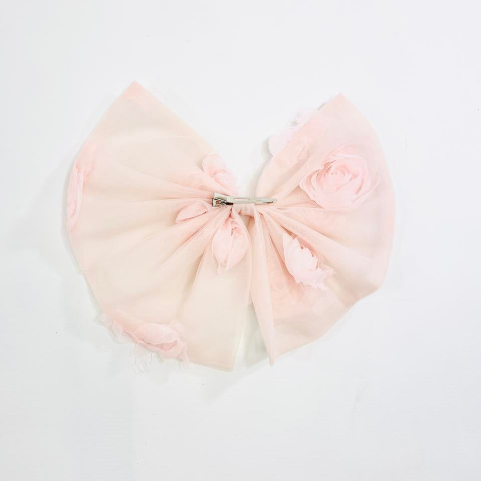 Pink bow-shaped pillow on a light gray background