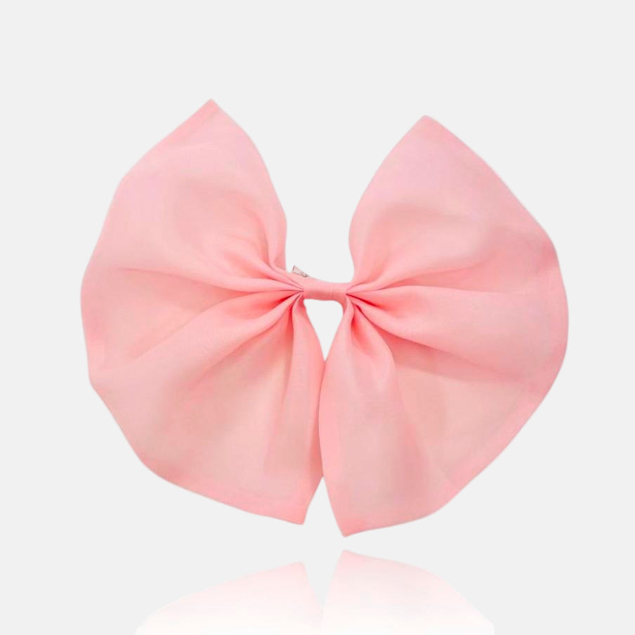 A large pink organza hair bow with a clip on the top for attaching to hair or clothing.