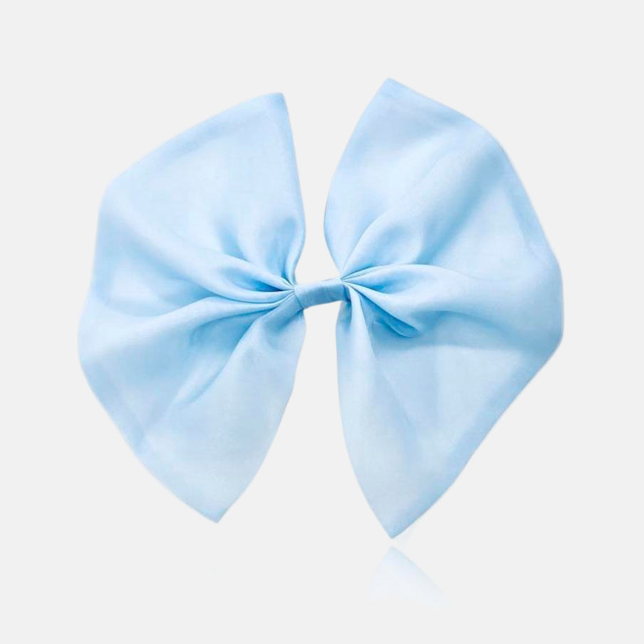 A light blue organza hair bow with a clip attached from DOLLY Le Petit Tom® , displayed against a white background.