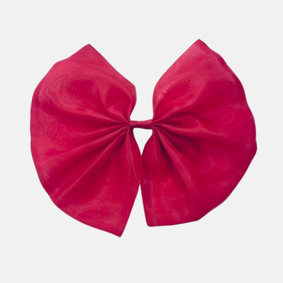A red organza hair bow with a clip on a white background.