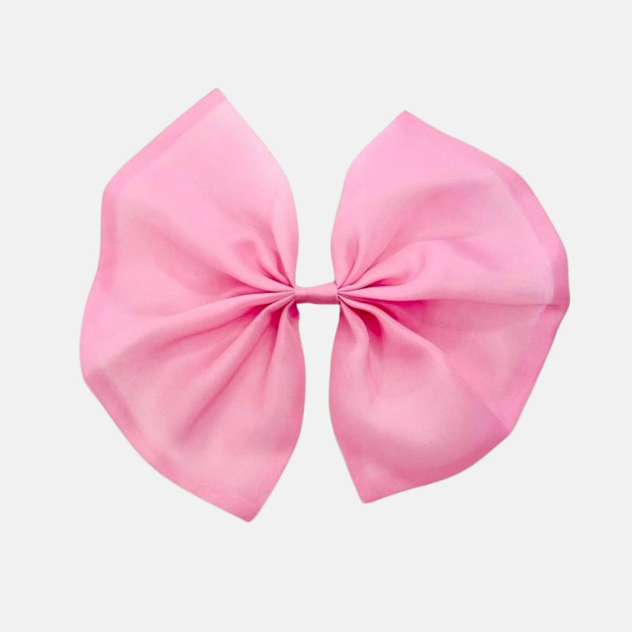 A large pink organza hair bow with a clip on a white background