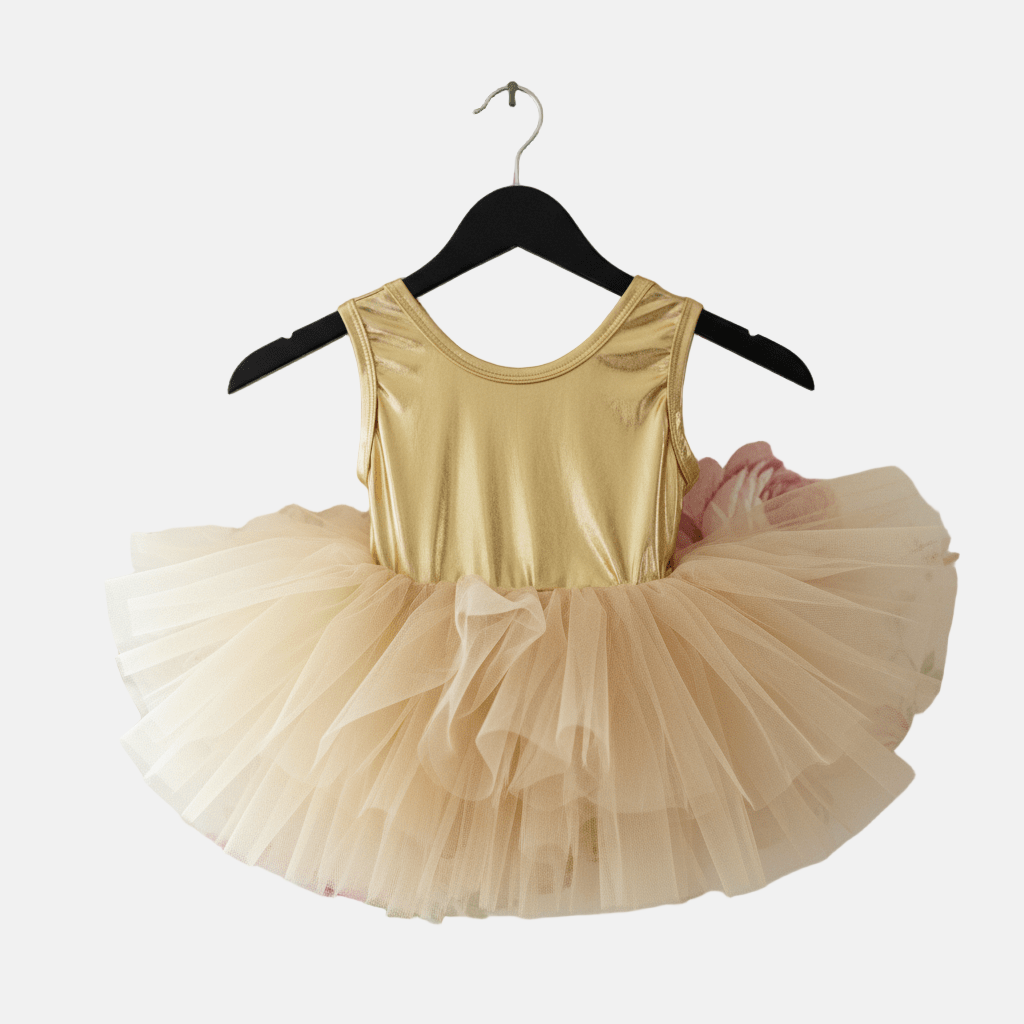 Gold tank top and beige tutu skirt on a hanger against a floral wallpaper background