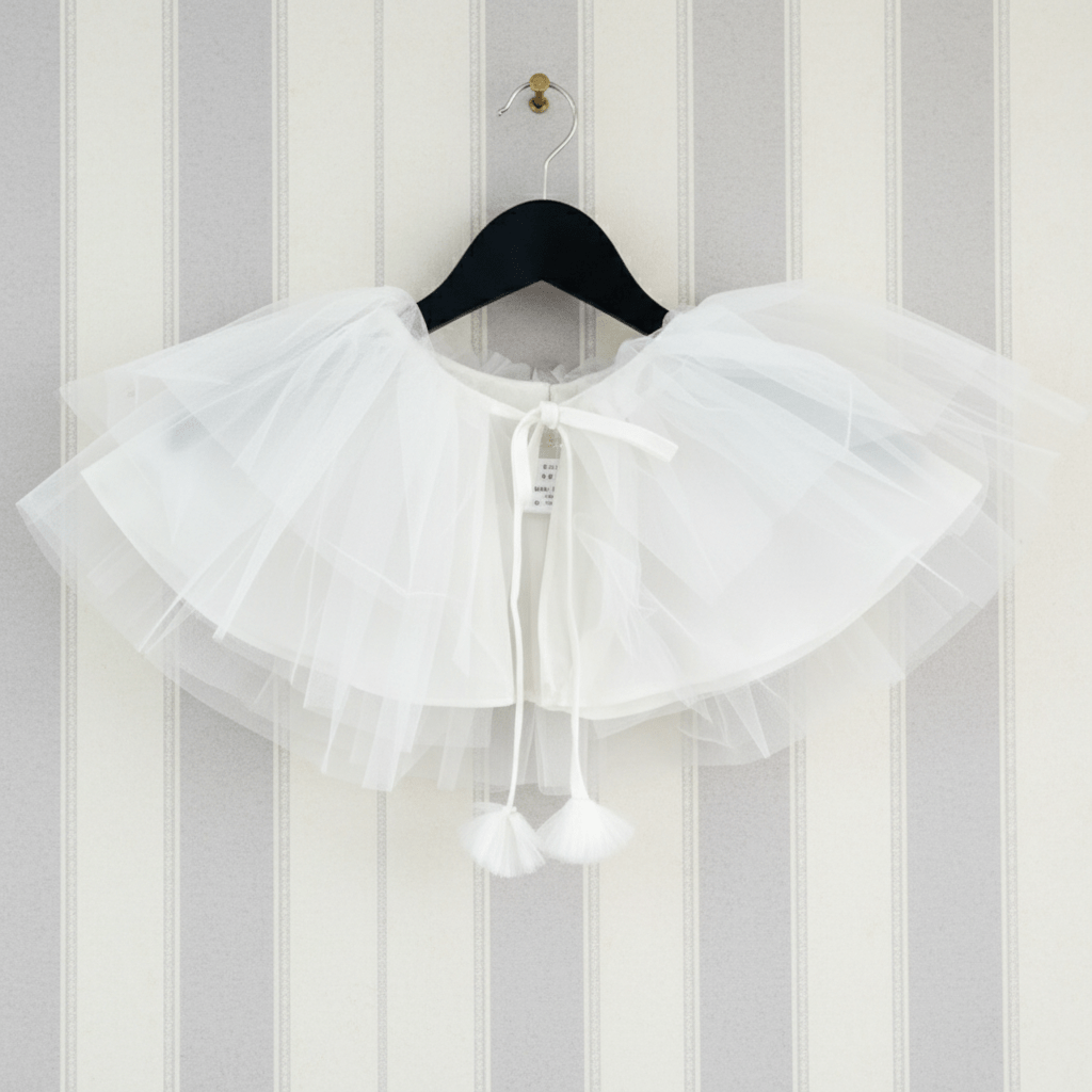 White lace collar on a hanger against a striped wall.