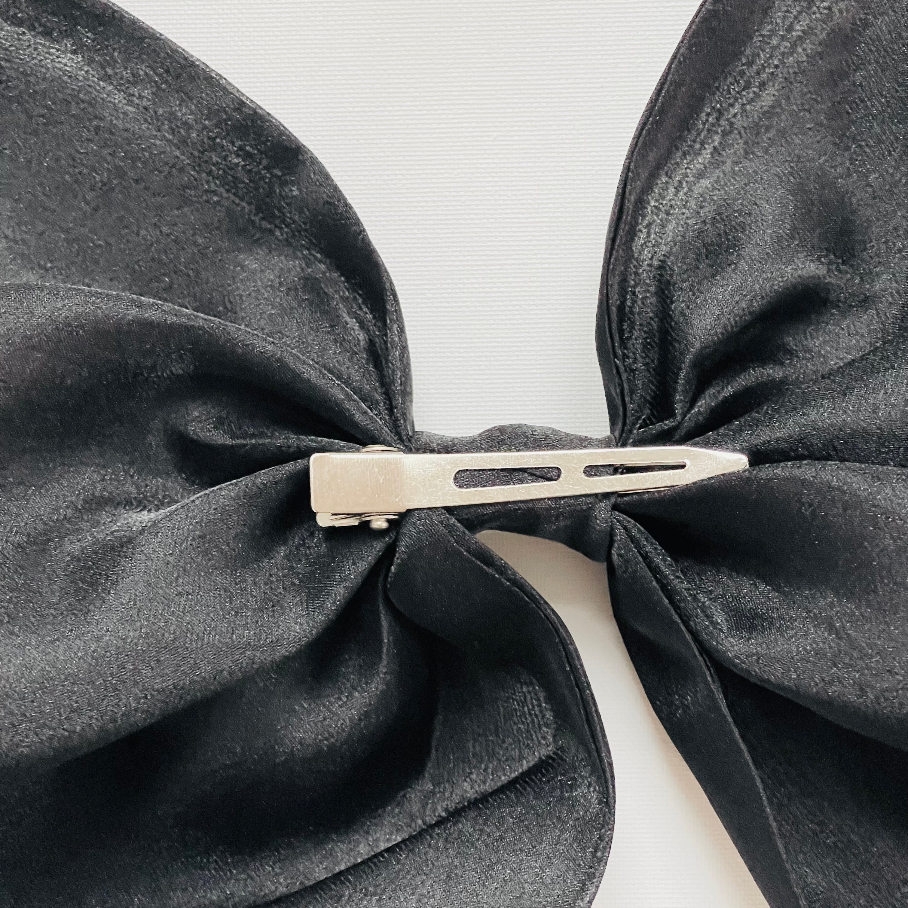 Black bow with a hair clip on a white background