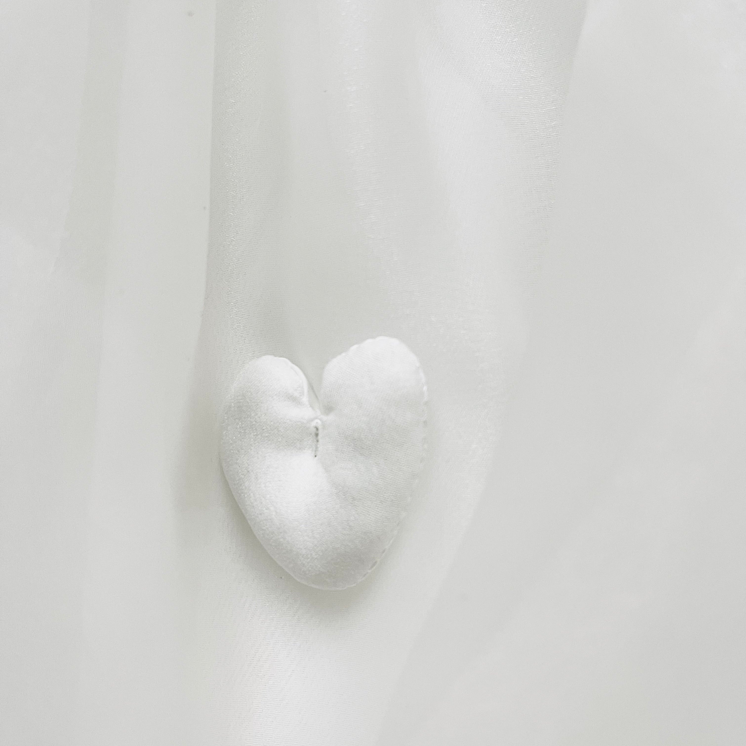Heart-shaped white object on a light gray background