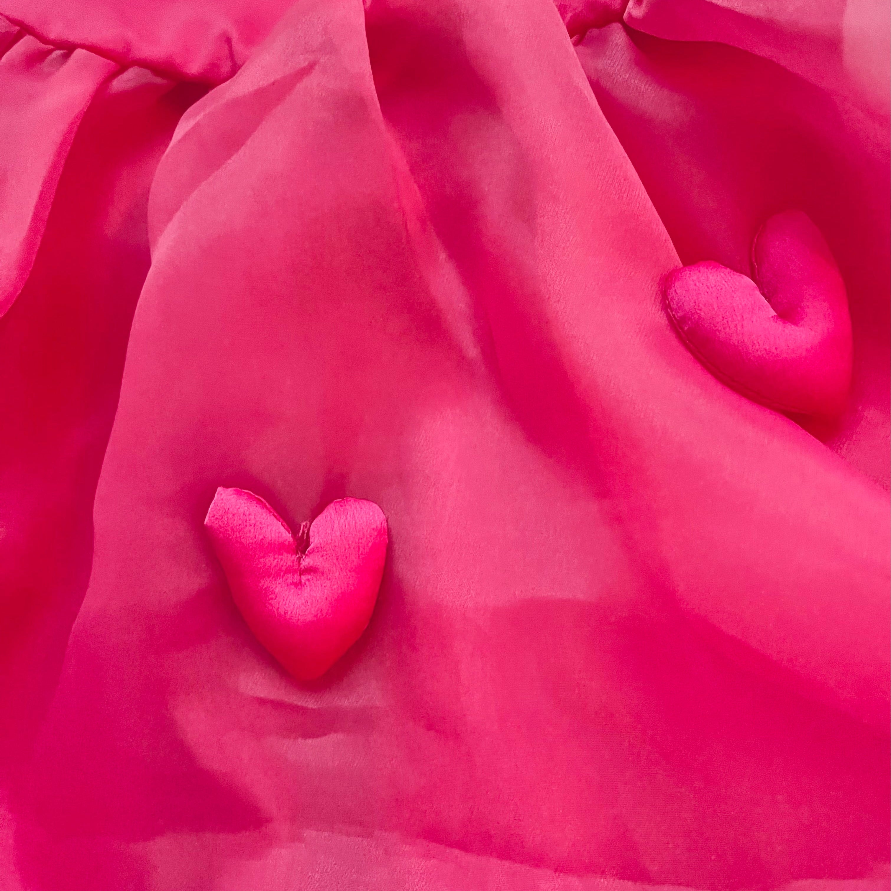 Close-up of a pink fabric with heart shapes
