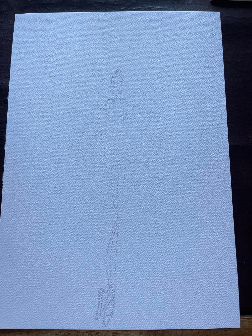 Light blue textured paper with a subtle embossed design on a dark background