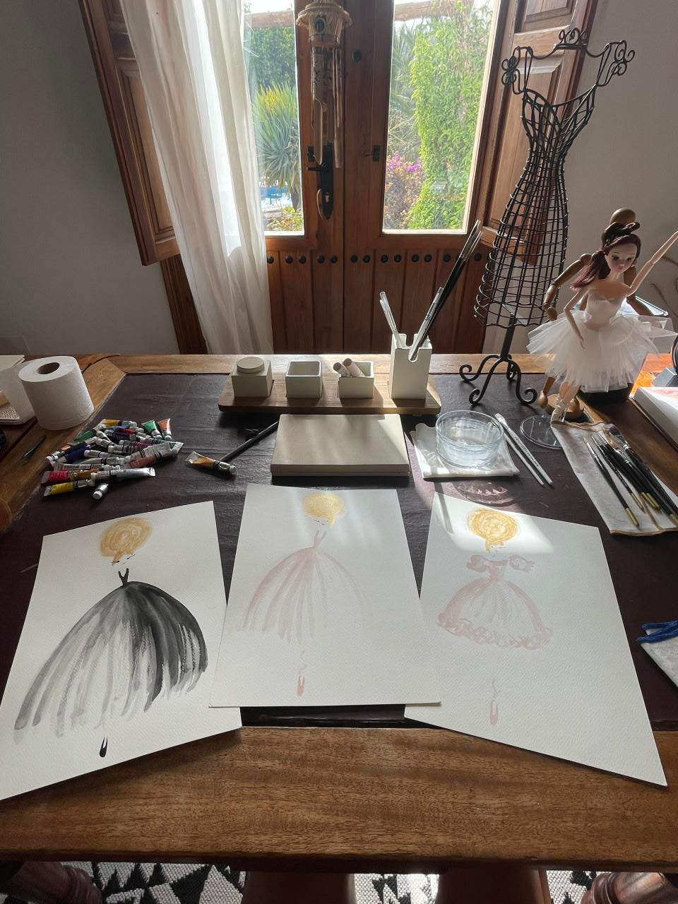 Artistic workspace with drawings on a table near a window