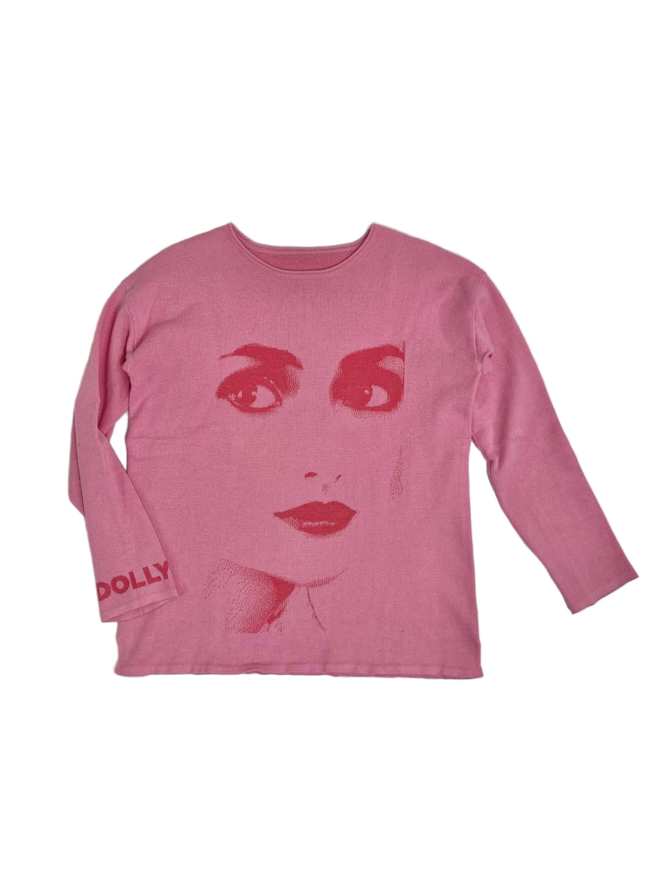 Pink long-sleeve shirt with a graphic of a DOLLY face on a white background