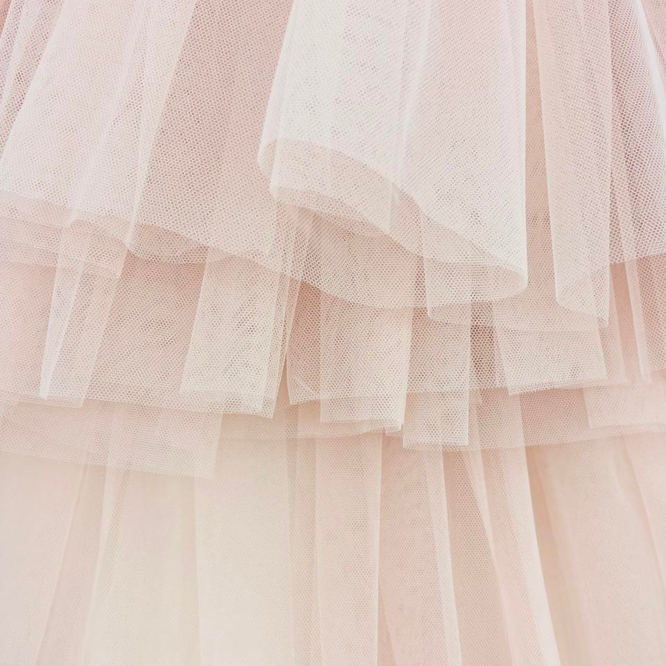 Close-up of layered tulle fabric in soft pink and white.