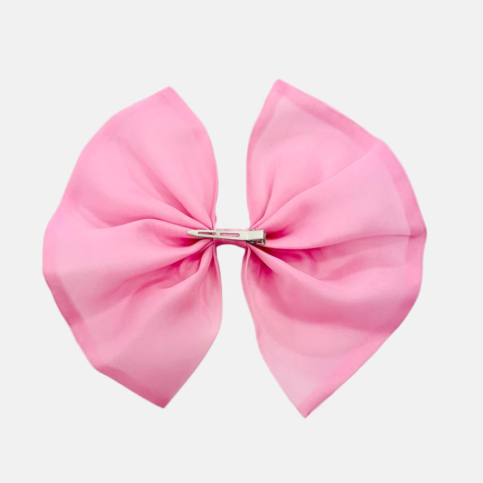 Large pink bow with a clip on a light gray background