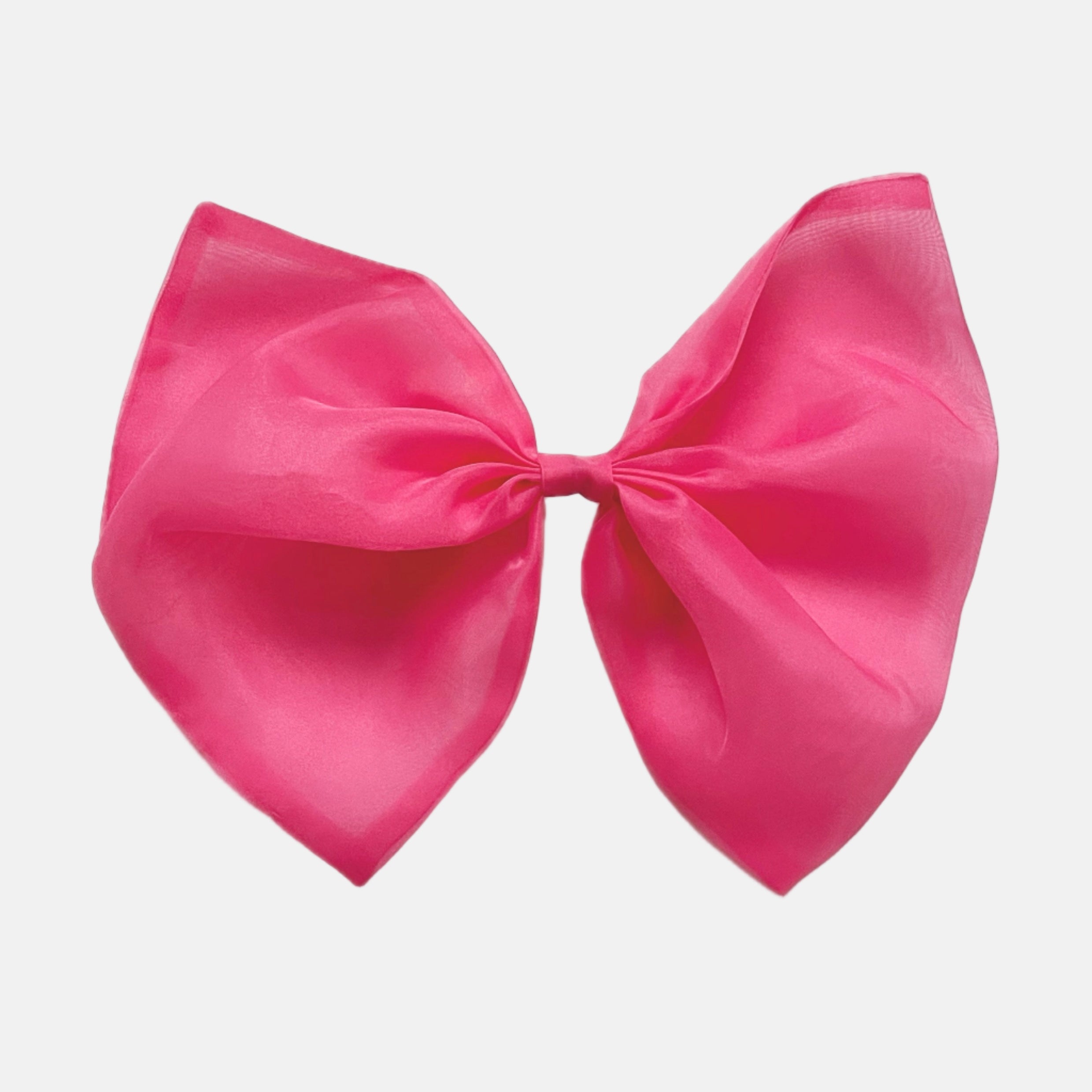 A large organza hair bow in barbie pink with a clip, designed to be worn in the hair or attached to clothing.