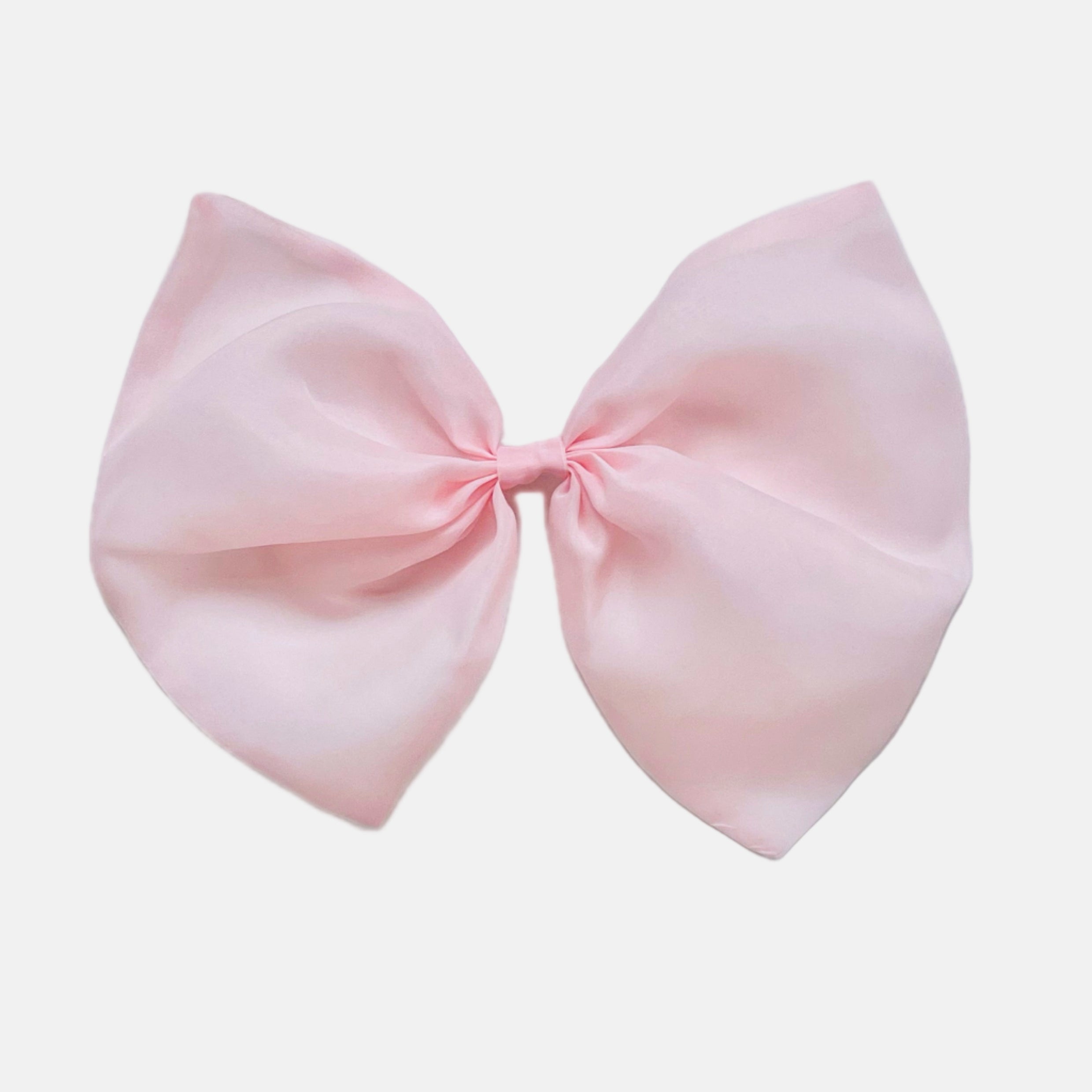 A large pink organza hair bow with a clip on the back, isolated on a white background.