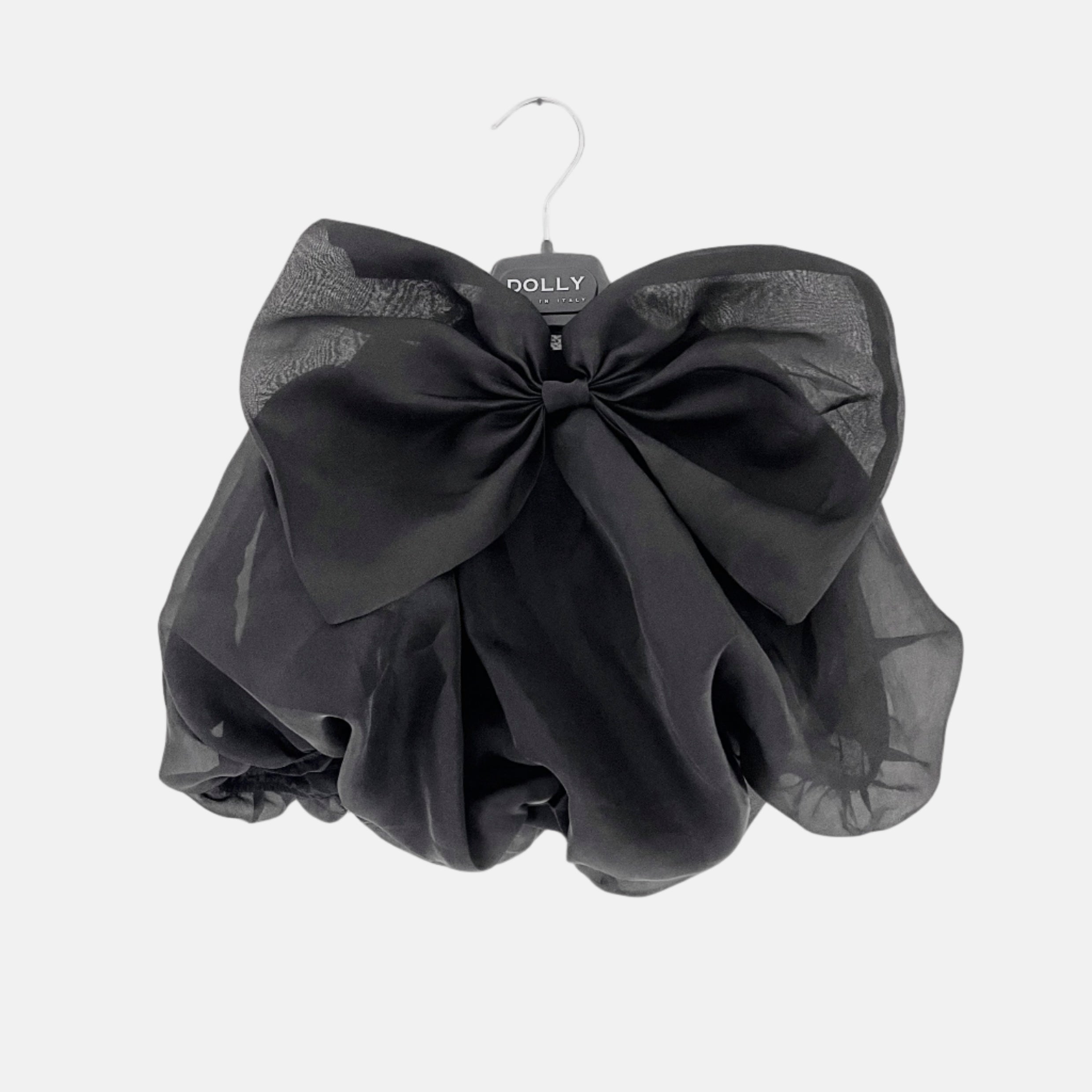 Black sheer skirt with a large bow on a hanger against a white background