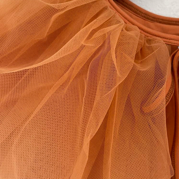 Close-up of orange tulle fabric with a blurred background
