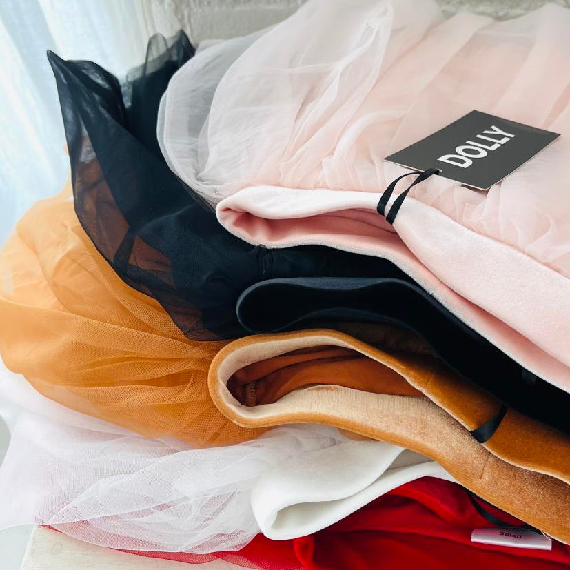 Stack of colorful fabrics with a DOLLY tag.