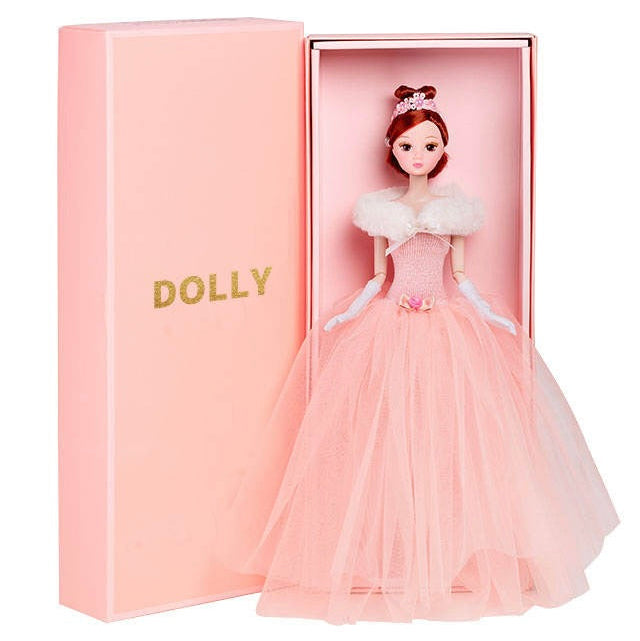 A 12-inch DOLLY® Queen fashion doll with a pink tutu dress, presented in a pink box with the DOLLY® logo.