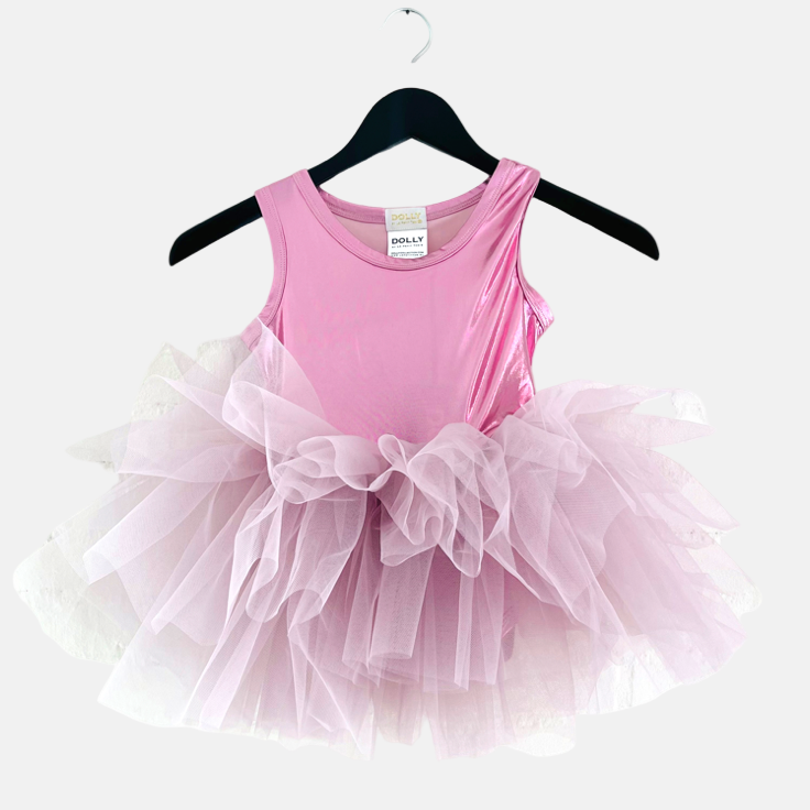 Pink dress with a tutu on a hanger against a white background