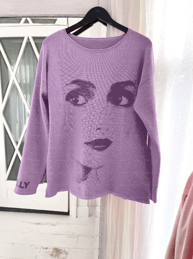 Purple sweater with a face design on a hanger against a white curtain background