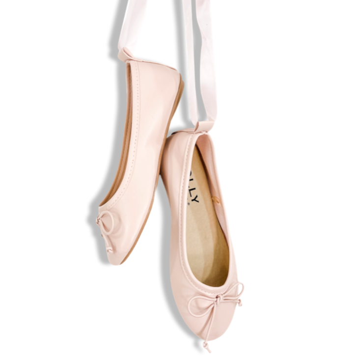 A pair of pink ballet flats with lace-up ribbons displayed against a white background, with the brand name 'DOLLY' visible on the shoes.