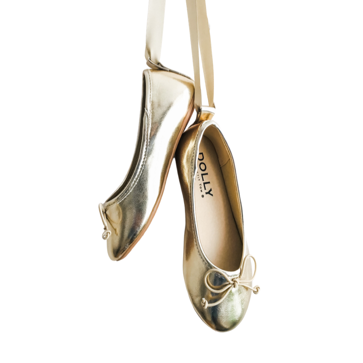 Gold ballet flats with 'Dolly' branding on a white background