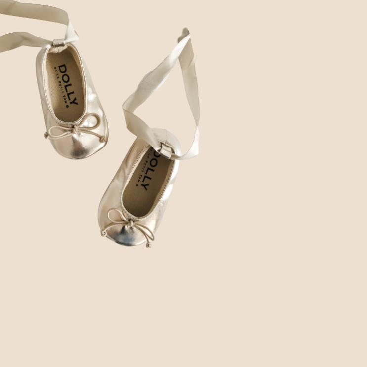 Silver ballet flats with ribbons on a beige background