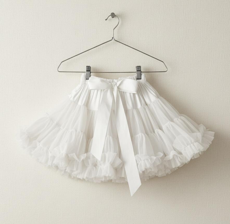 White tulle skirt on a hanger against a plain background