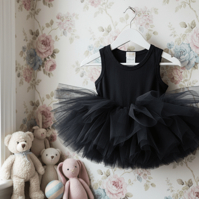Black tutu dress on a hanger against a floral wallpaper background with stuffed toys below.