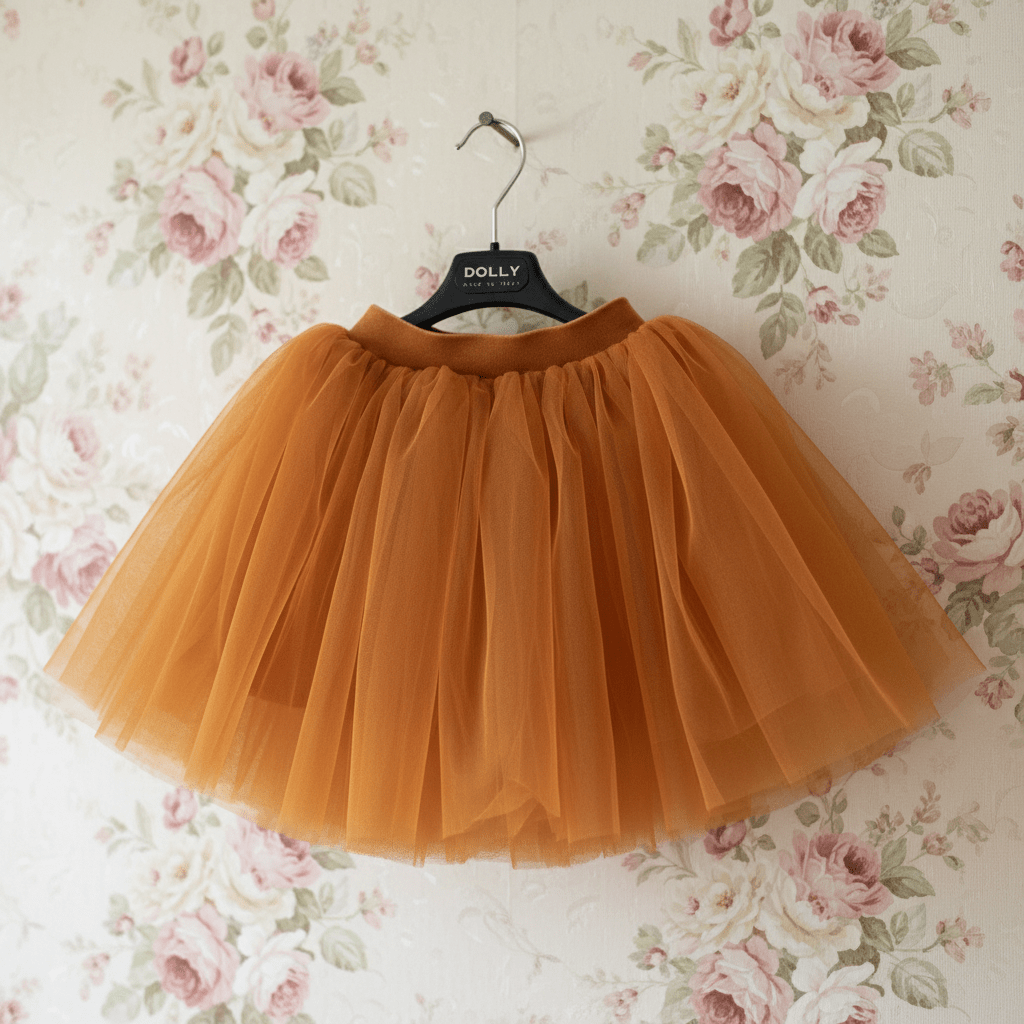 Caramel tulle skirt on a hanger against a floral wallpaper background