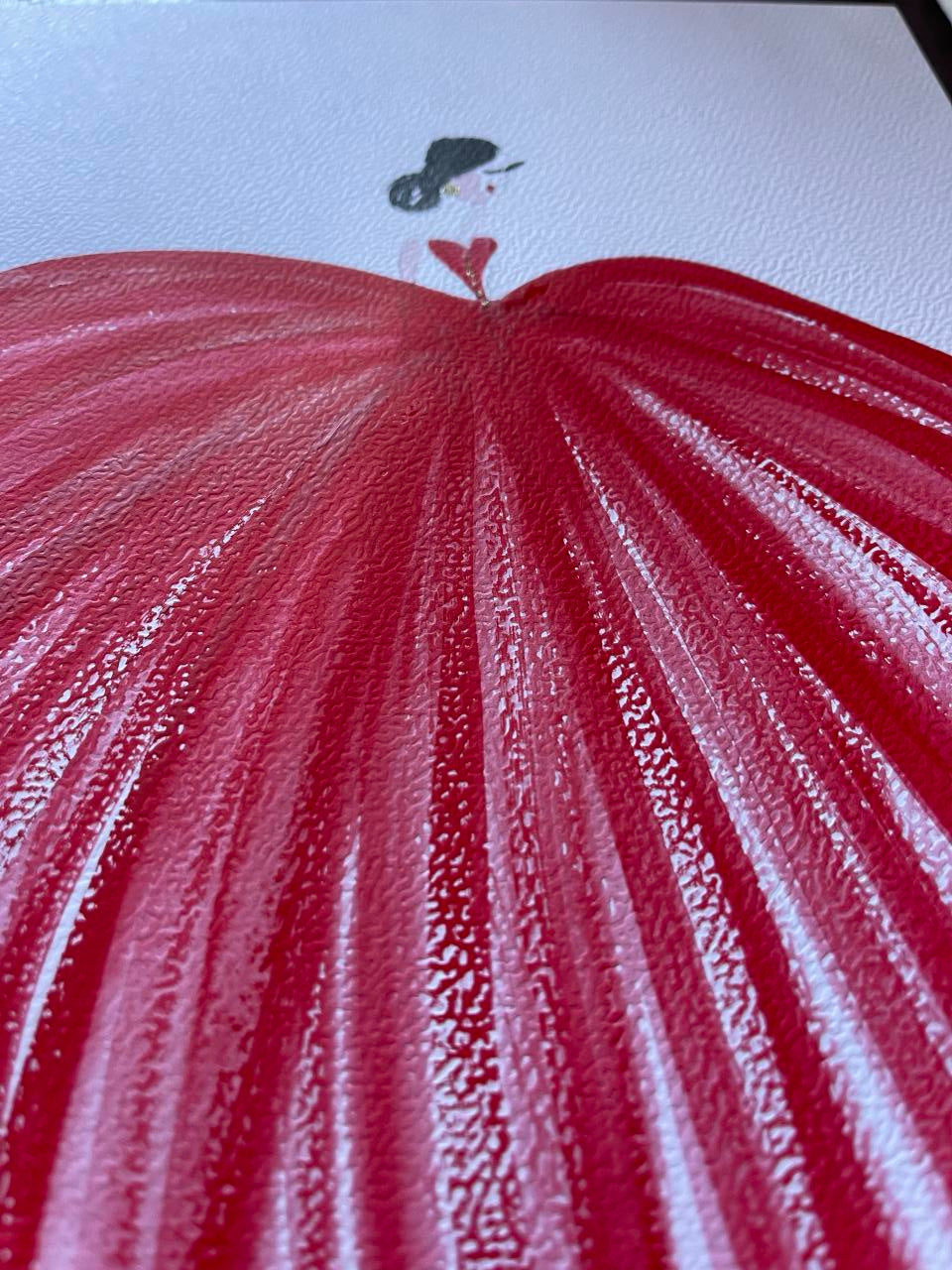 Close-up of a red fabric texture with a small black and white illustration on a light blue background.