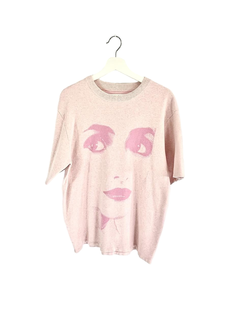 Pink t-shirt with face design on a white background