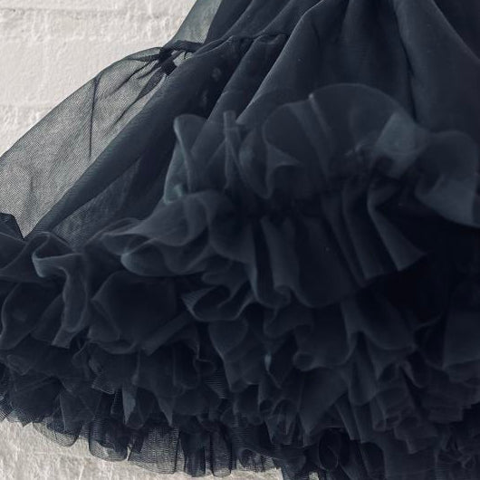 Black tulle skirt on a textured surface