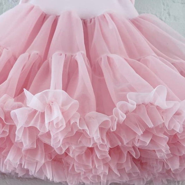 Close-up of a pink tutu skirt with ruffles on a light background