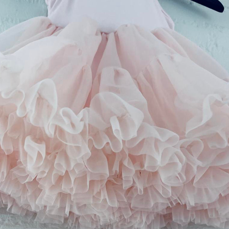 Close-up of a pink ruffled skirt on a light background